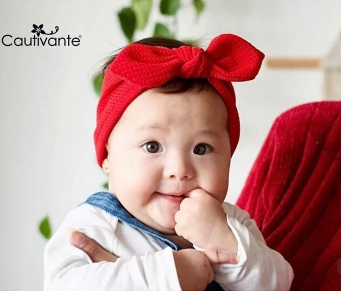 Baby mit rotem Haarband mit Knoten und Schleife